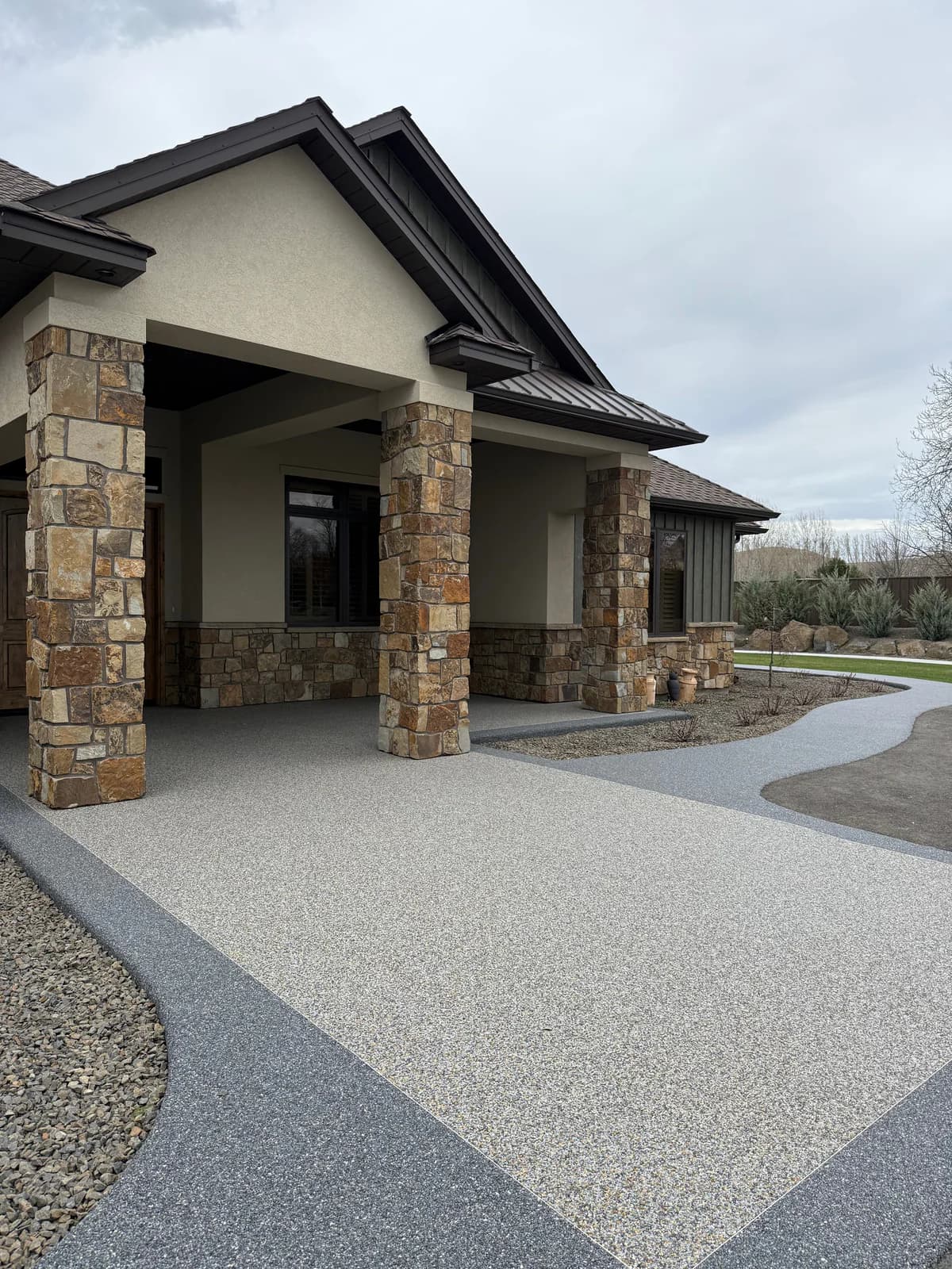 Resin-bound natural stone surface installed across a residential front entry and walkway